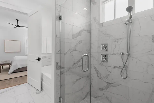 a bathroom with a granite countertop toilet sink shower and mirror