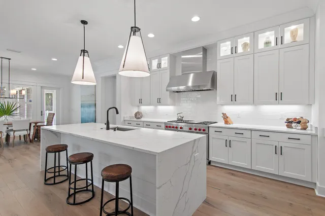 a kitchen with granite countertop a stove a sink and a refrigerator