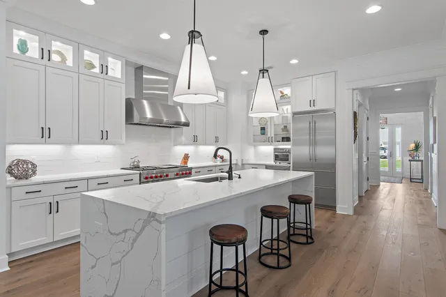 a utility room with stainless steel appliances granite countertop a stove and a sink