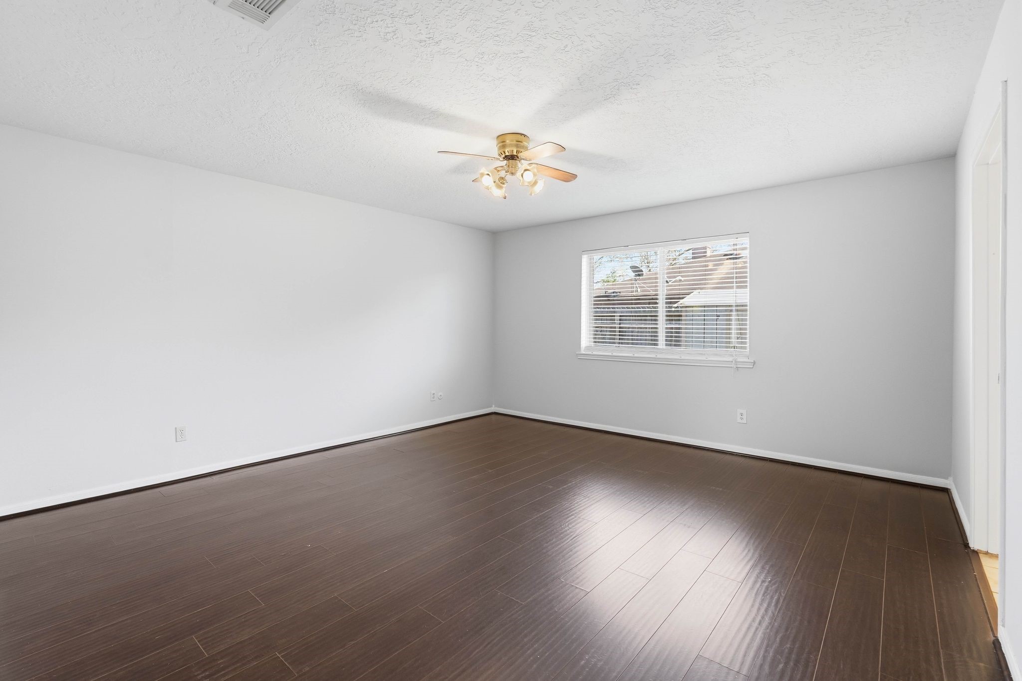 6807 Falling Waters Drive Spring, TX 77379 - Photo 11 of 22 an empty room with wooden floor chandelier fan and windows