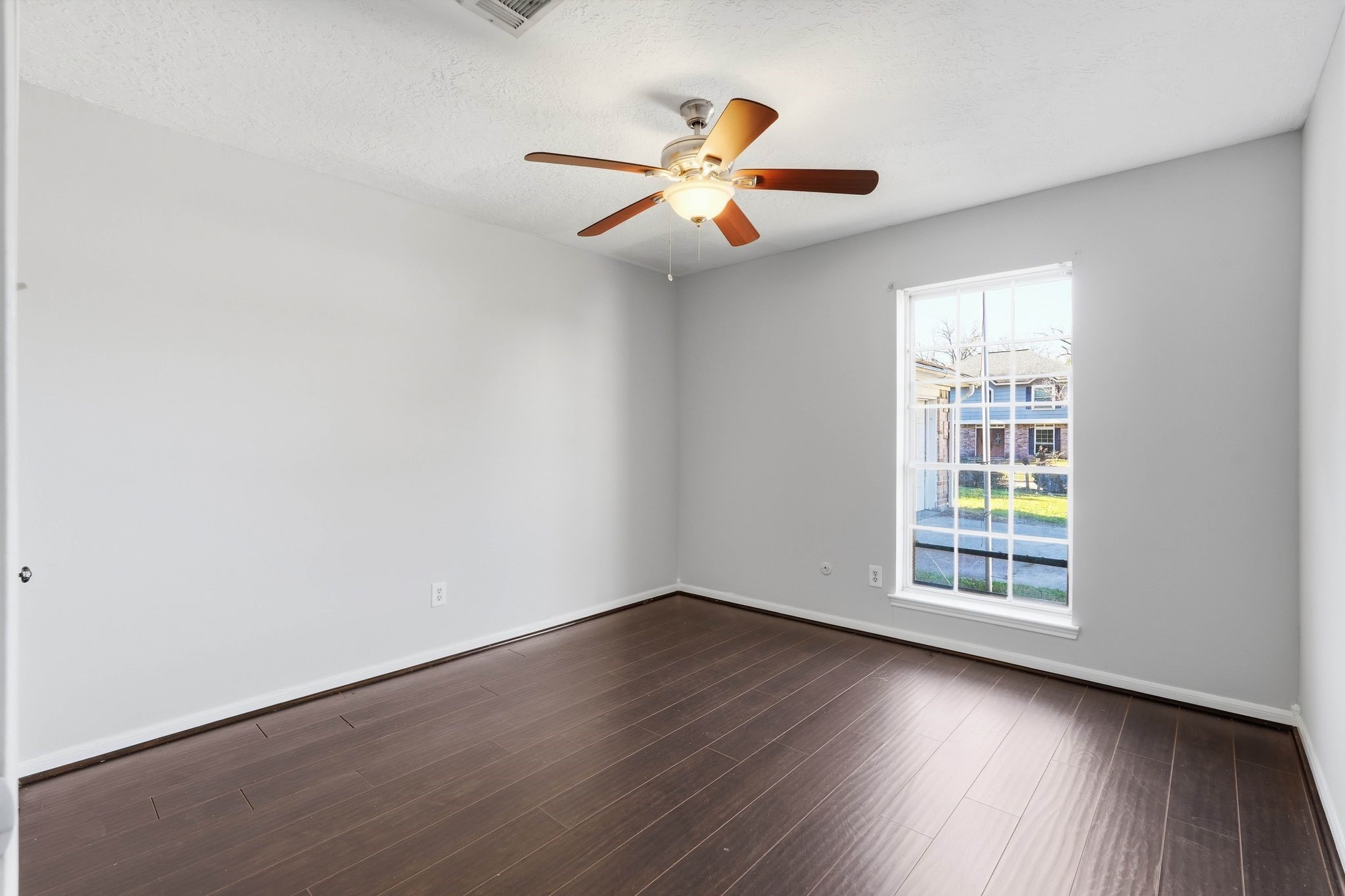 6807 Falling Waters Drive Spring, TX 77379 - Photo 15 of 22 an empty room with wooden floor fan and windows