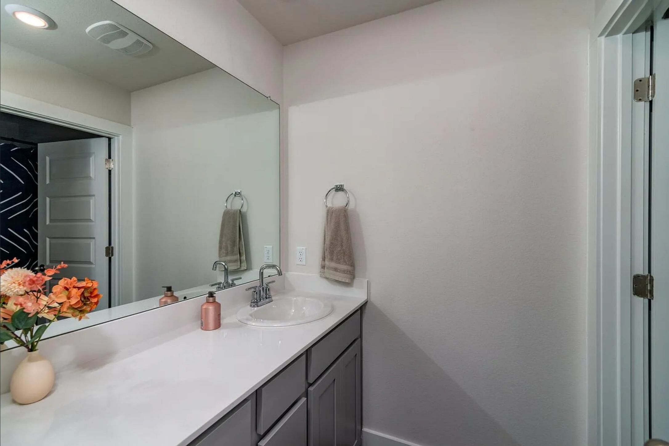 7501 Travertine Spring Drive Austin, TX 78744 - Photo 24 of 28 Bathroom vanity featuring a rectangular undermount sink, a white countertop, and gray cabinetry