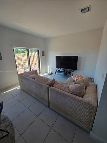 a living room with couches and a flat screen tv
