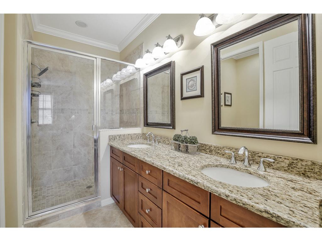 9041 Alturas Street, Unit 3803 Naples, FL 34113 - Photo 12 of 18 a bathroom with a granite countertop sink mirror and a shower