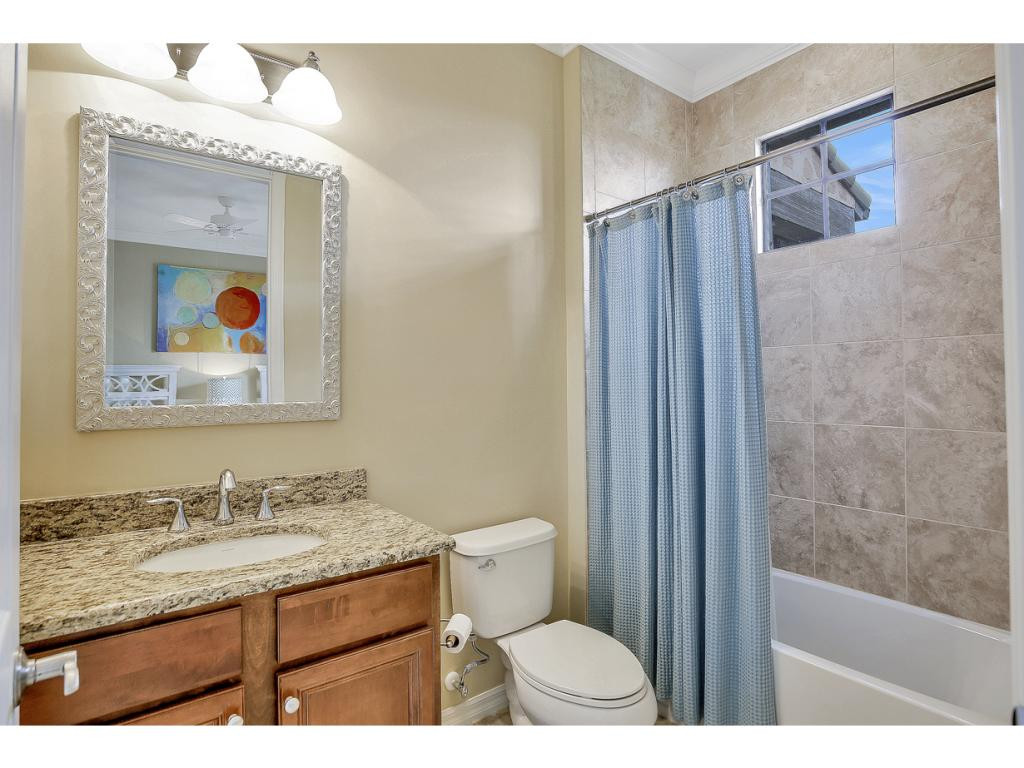 9041 Alturas Street, Unit 3803 Naples, FL 34113 - Photo 14 of 18 a bathroom with a granite countertop sink toilet and shower