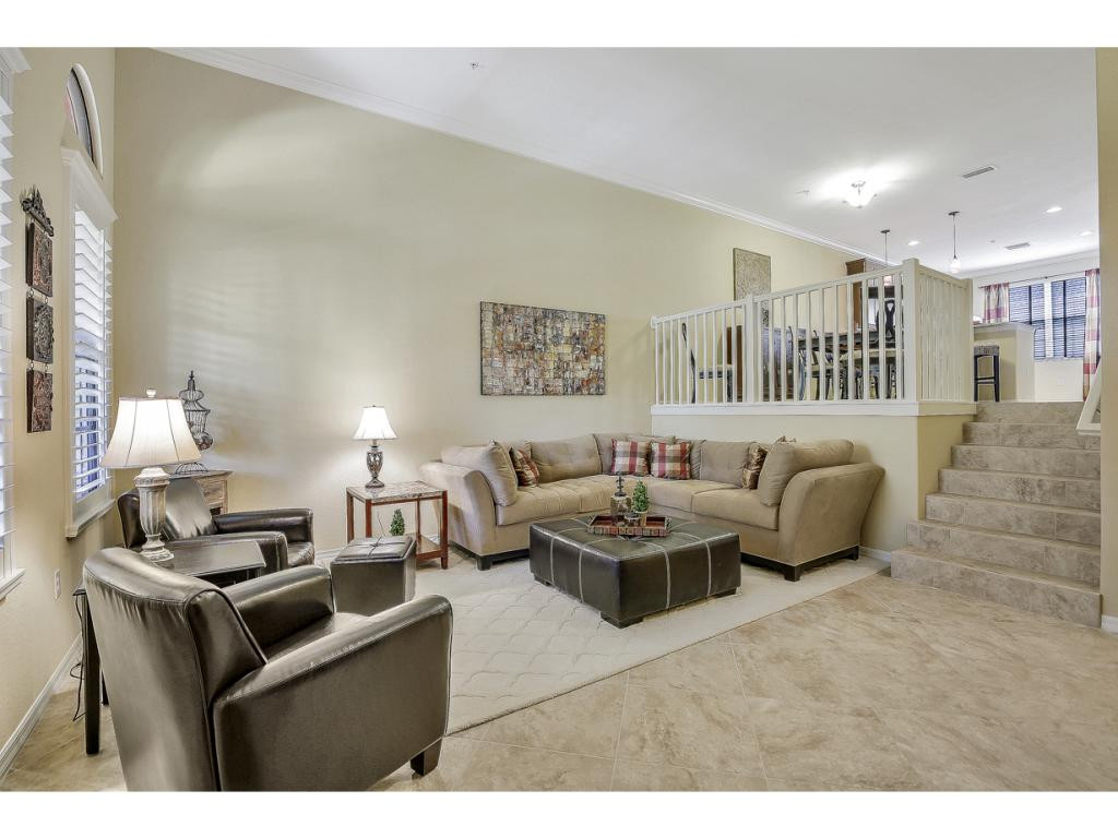 9041 Alturas Street, Unit 3803 Naples, FL 34113 - Photo 4 of 18 a living room with furniture a couch and a bookshelf