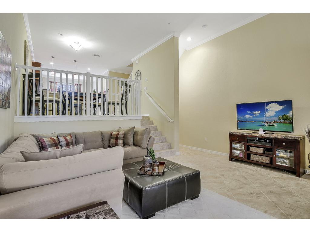 9041 Alturas Street, Unit 3803 Naples, FL 34113 - Photo 5 of 18 a living room with furniture and a flat screen tv