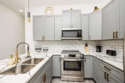 a kitchen with stainless steel appliances granite countertop a sink stove and microwave
