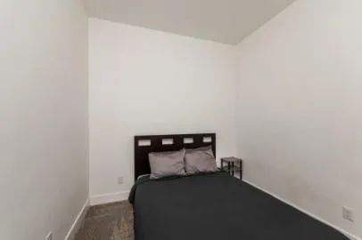 a bed sitting in a bedroom next to a small yard