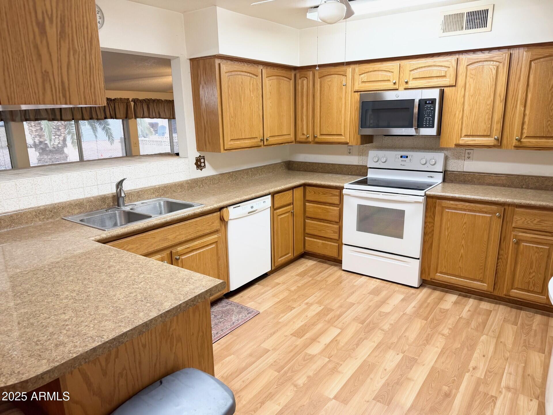823 South 79th Way Mesa, AZ 85208 - Photo 5 of 46 a kitchen with stainless steel appliances granite countertop a sink stove and microwave