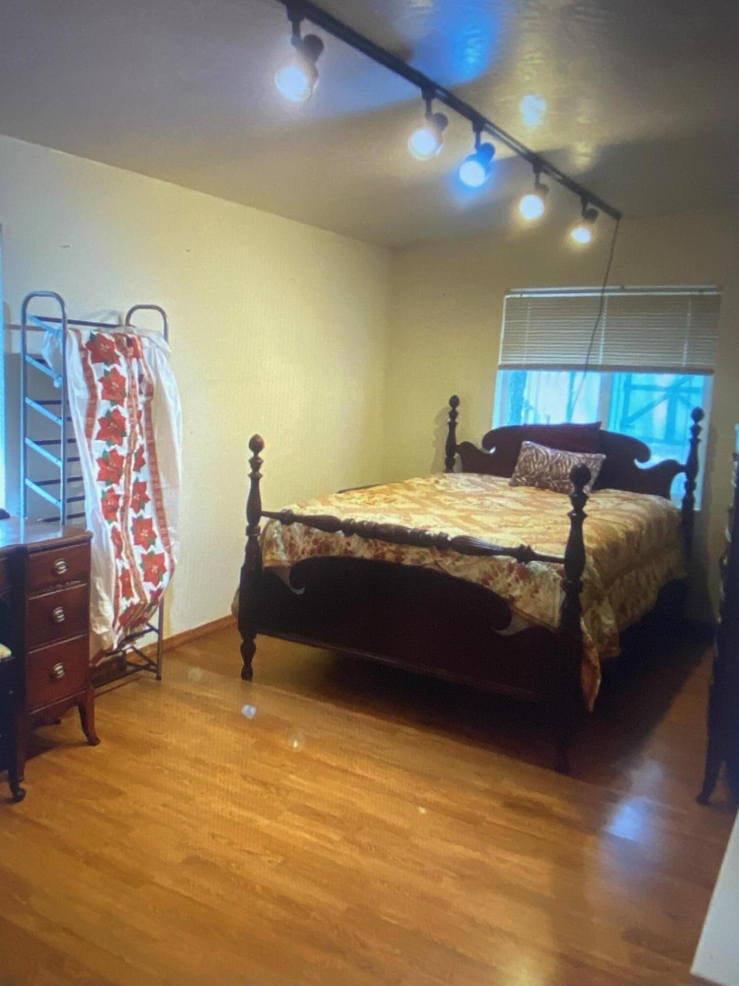 780 Lone Mountain Road O'Brien, OR 97534 - Photo 25 of 33 a bedroom with a bed and wooden floor
