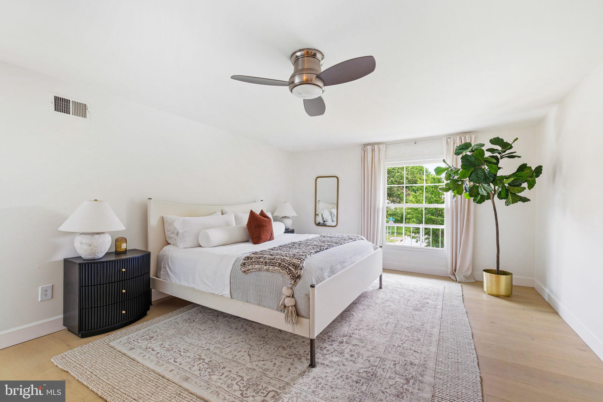 10900 Gainsborough Road Potomac, MD 20854 - Photo 25 of 44 a spacious bedroom with a bed lamp and a potted plant