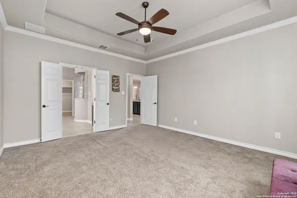 an empty room with closet and a ceiling fan