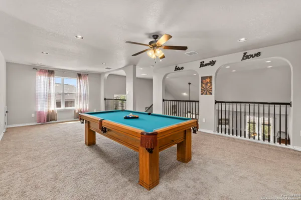 a room with pool table and windows