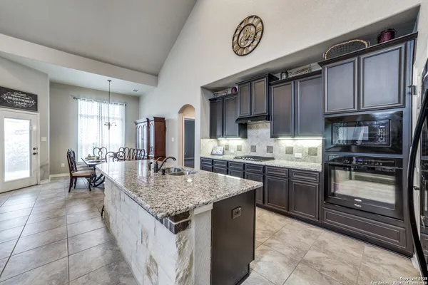 a kitchen with stainless steel appliances granite countertop a sink dishwasher stove and refrigerator
