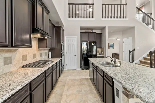 a kitchen with stainless steel appliances granite countertop a sink stove and cabinets