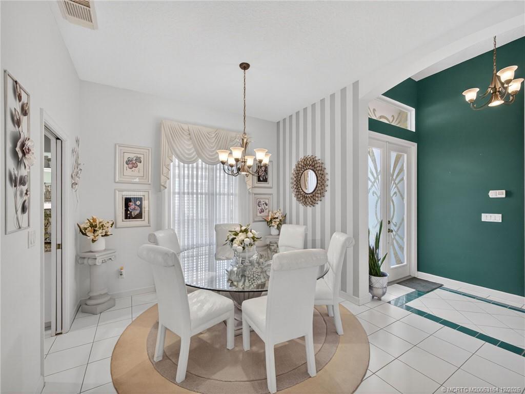618 Southwest Lake Charles Circle Port St. Lucie, FL 34986 - Photo 12 of 29 a view of a dining room with furniture a chandelier and wooden floor