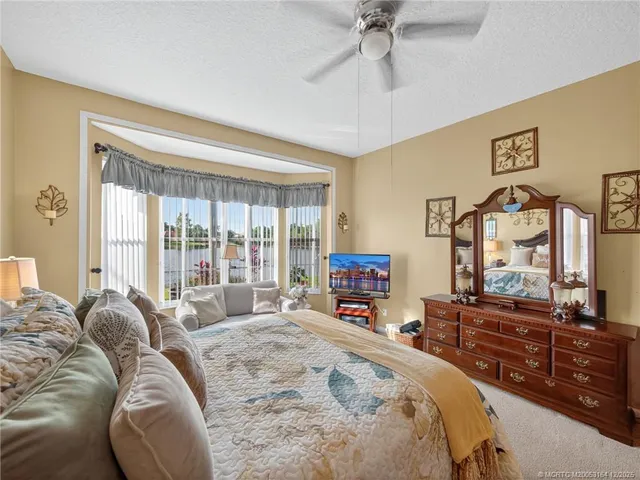 a spacious bedroom with a bed a dresser and a flat screen tv