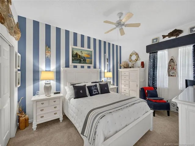 a bedroom with a bed a window and a flat screen tv