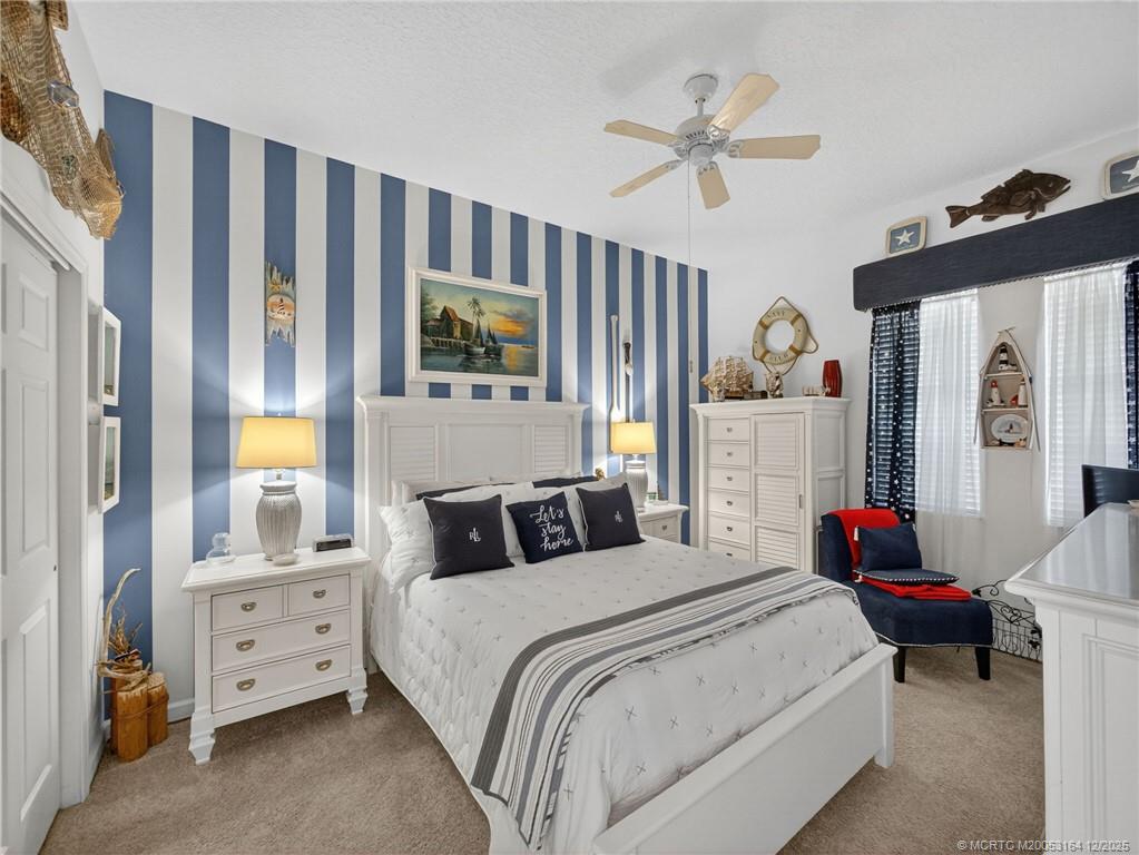 618 Southwest Lake Charles Circle Port St. Lucie, FL 34986 - Photo 19 of 29 a bedroom with a bed a window and a flat screen tv