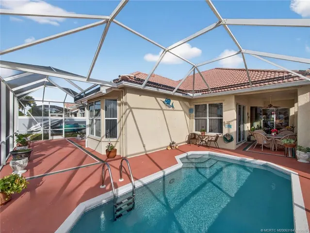 a view of a backyard with table and chairs under an umbrella