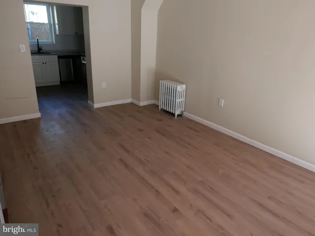 a view of a kitchen with wooden floor and electronic appliances