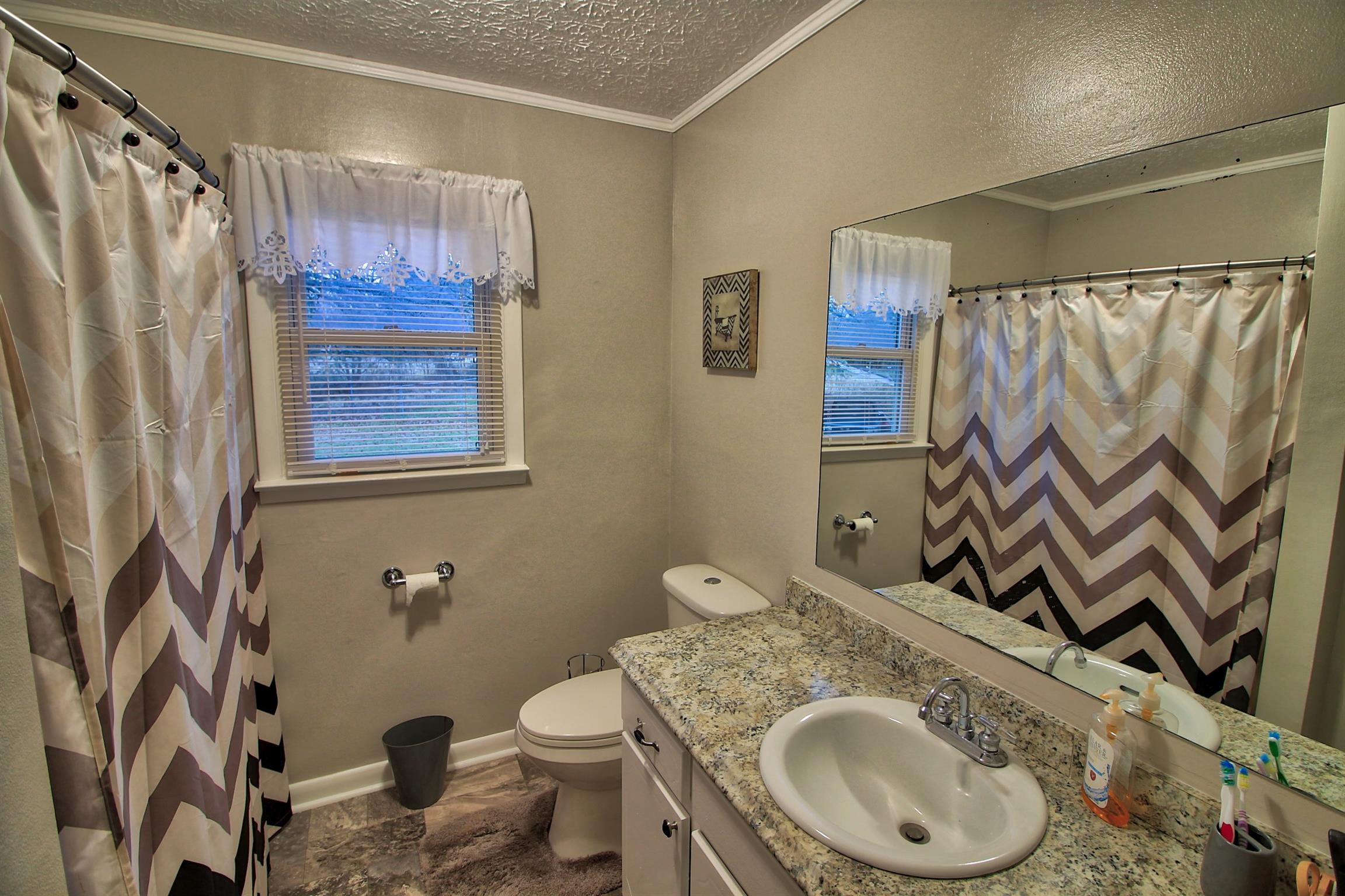 350 Jim Courtney Road Portland, TN 37148 - Photo 12 of 16 a bathroom with a granite countertop sink and a mirror