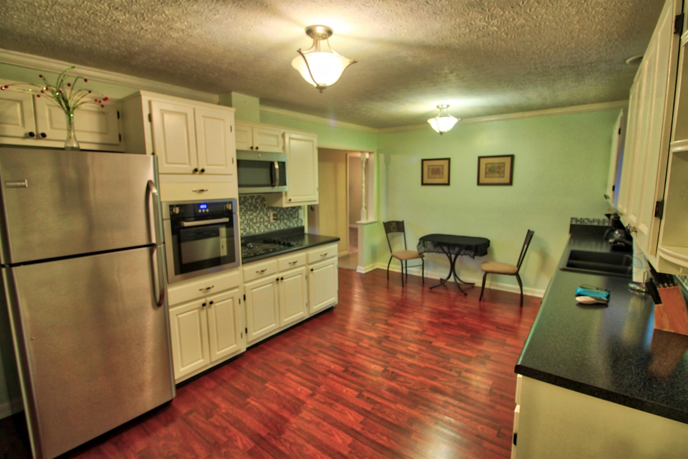 350 Jim Courtney Road Portland, TN 37148 - Photo 8 of 16 a kitchen with stainless steel appliances a refrigerator a stove top oven a dining table and chairs