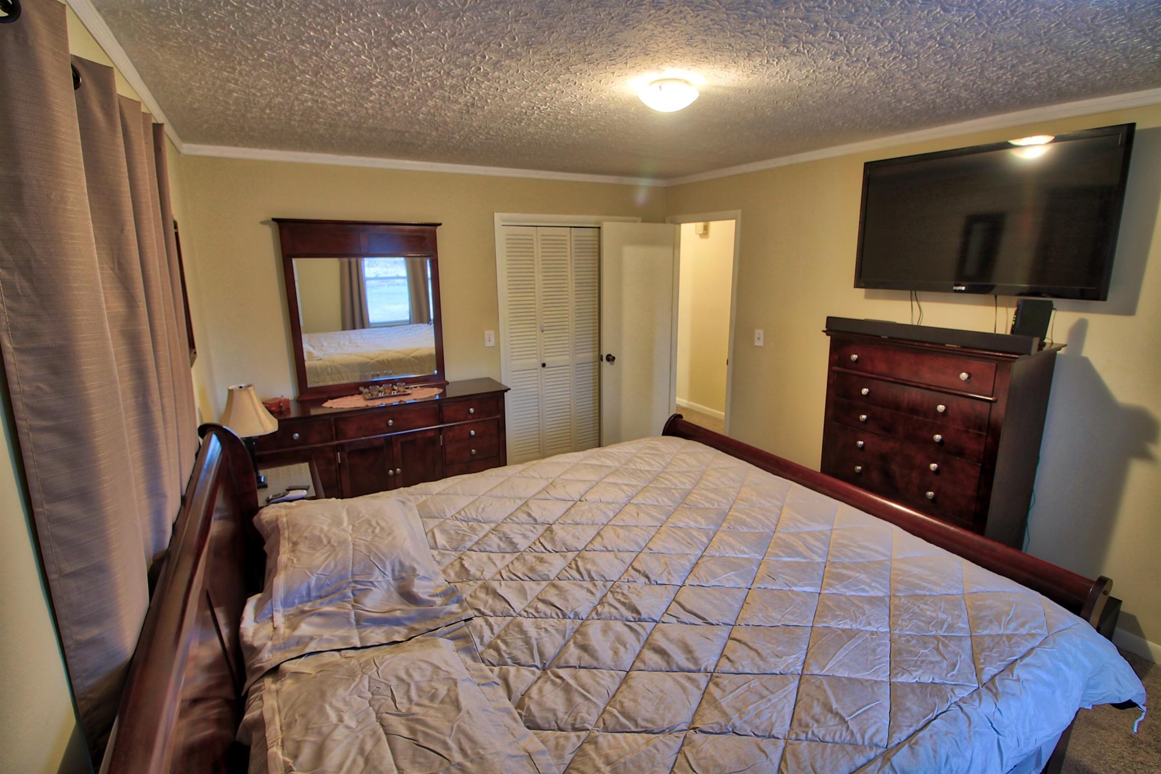350 Jim Courtney Road Portland, TN 37148 - Photo 10 of 16 a bedroom with a bed and a flat screen tv