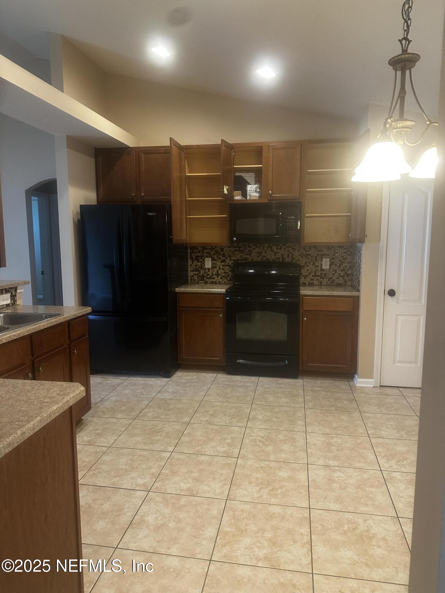 45157 Ingleham Circle Callahan, FL 32011 - Photo 12 of 48 a kitchen with stainless steel appliances kitchen island granite countertop a refrigerator and a stove