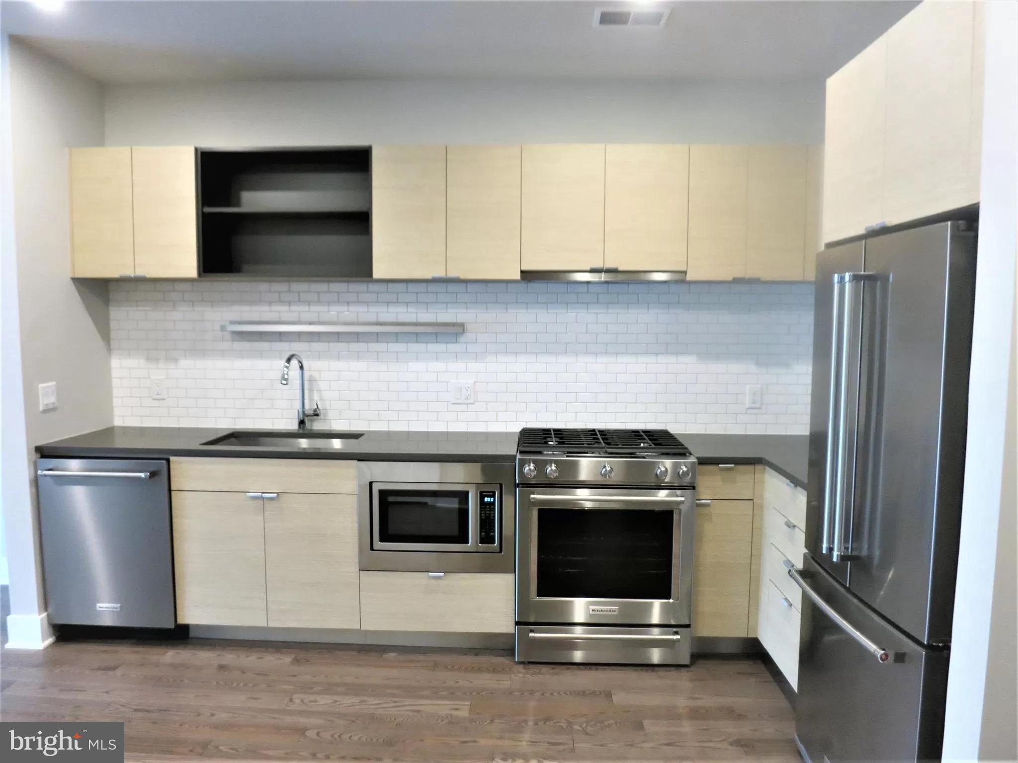 a kitchen with stainless steel appliances a stove a microwave and a sink