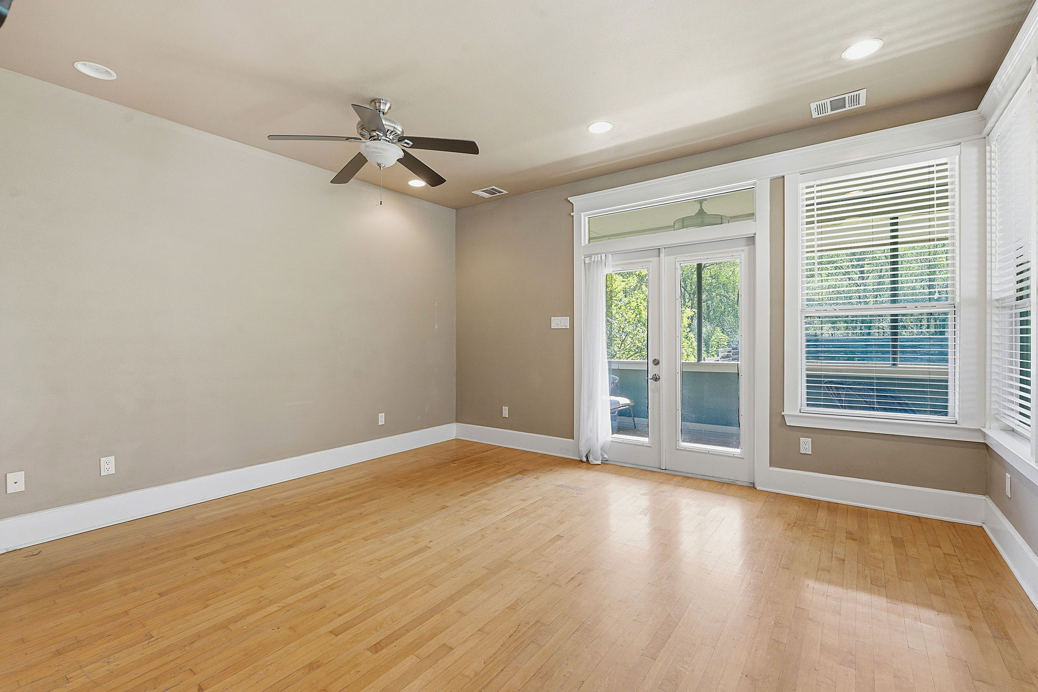 1305 Cometa Street Austin, TX 78721 - Photo 9 of 28 Hardwood floors and generous natural light enhance this well-proportioned living space with balcony access.