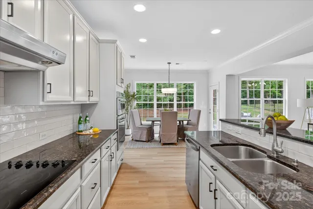 a kitchen with stainless steel appliances granite countertop a sink stove and cabinets