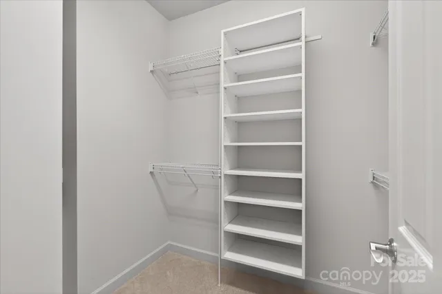 a view of walk in closet with empty racks