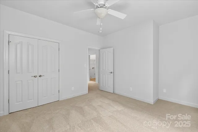 a view of an empty room and a ceiling fan