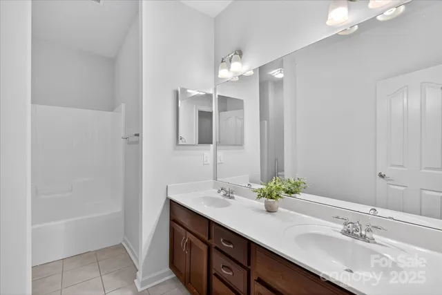 a bathroom with a sink double vanity granite tub and a mirror