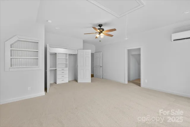 an empty room with closet and a ceiling fan