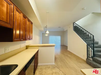 a view of a kitchen with wooden floor and a ceiling fan