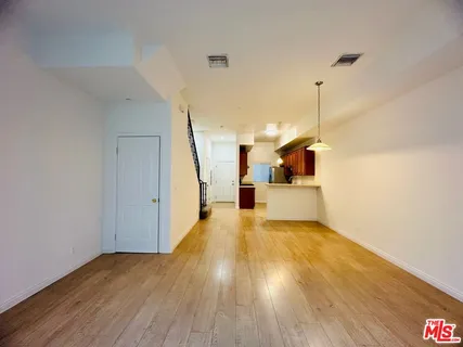 a view of a kitchen with wooden floor and a ceiling fan