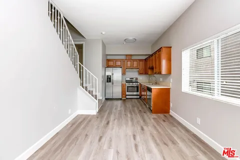 a kitchen with stainless steel appliances kitchen island granite countertop a stove a sink and a refrigerator