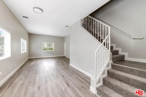 a view of a room with wooden floor and entryway