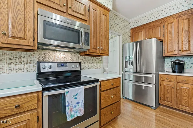 a kitchen with granite countertop a refrigerator stove and microwave