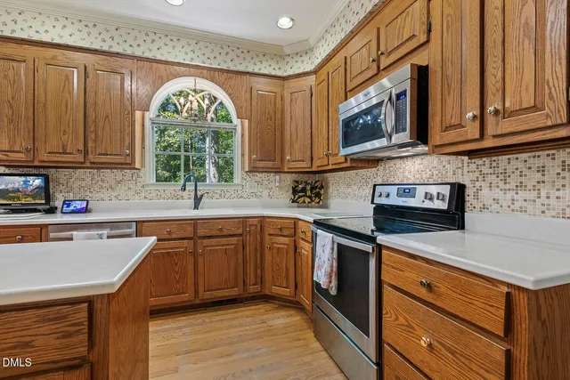 a kitchen with stainless steel appliances granite countertop a sink a stove microwave and cabinets