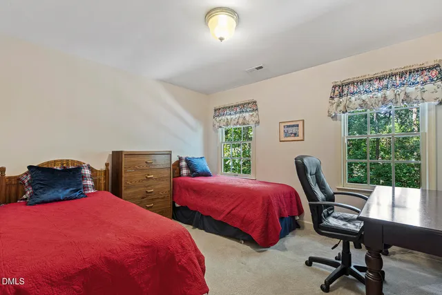 a bedroom with two beds and a desk