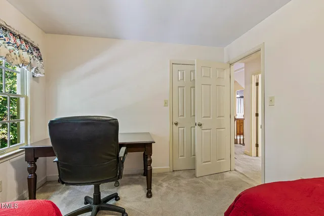 a view of a workspace with furniture and a window