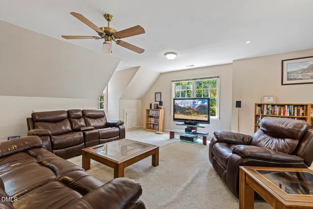 a living room with furniture ceiling fan and a window