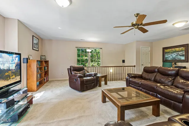 a living room with furniture a ceiling fan and a window