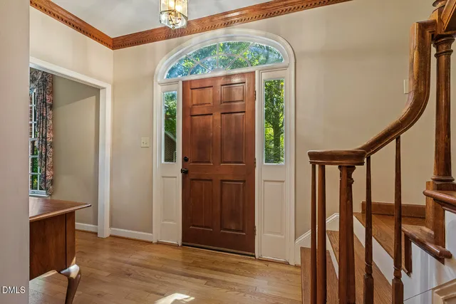 an entryway with wooden floor and stairs