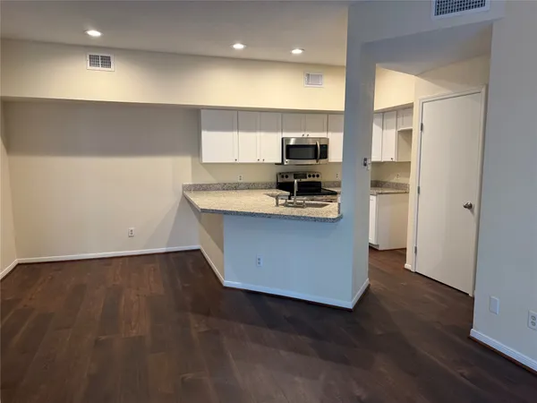a kitchen with stainless steel appliances a refrigerator and a stove top oven
