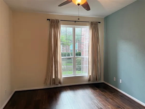an empty room with wooden floor and mirror